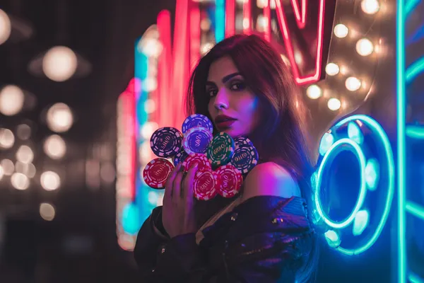 Một cô gái trong bộ váy xanh sang trọng đứng cạnh vòng roulette, gợi lên bầu không khí casino cao cấp của QWE123.